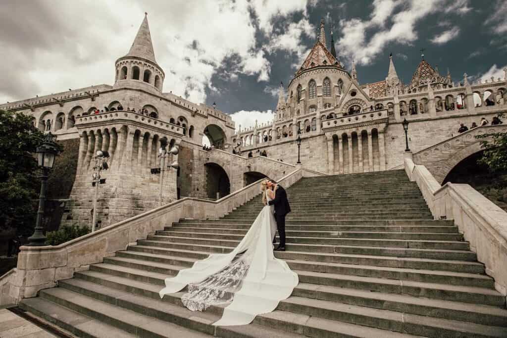 Luxurious castle wedding venue with romantic couple on grand staircase, perfect for high-end wedding celebrations.
