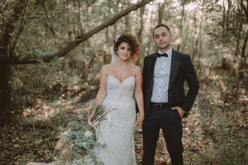 Elegant bride and groom in a luxurious woodland wedding setting, highlighting high-end wedding photography and romantic atmosphere.