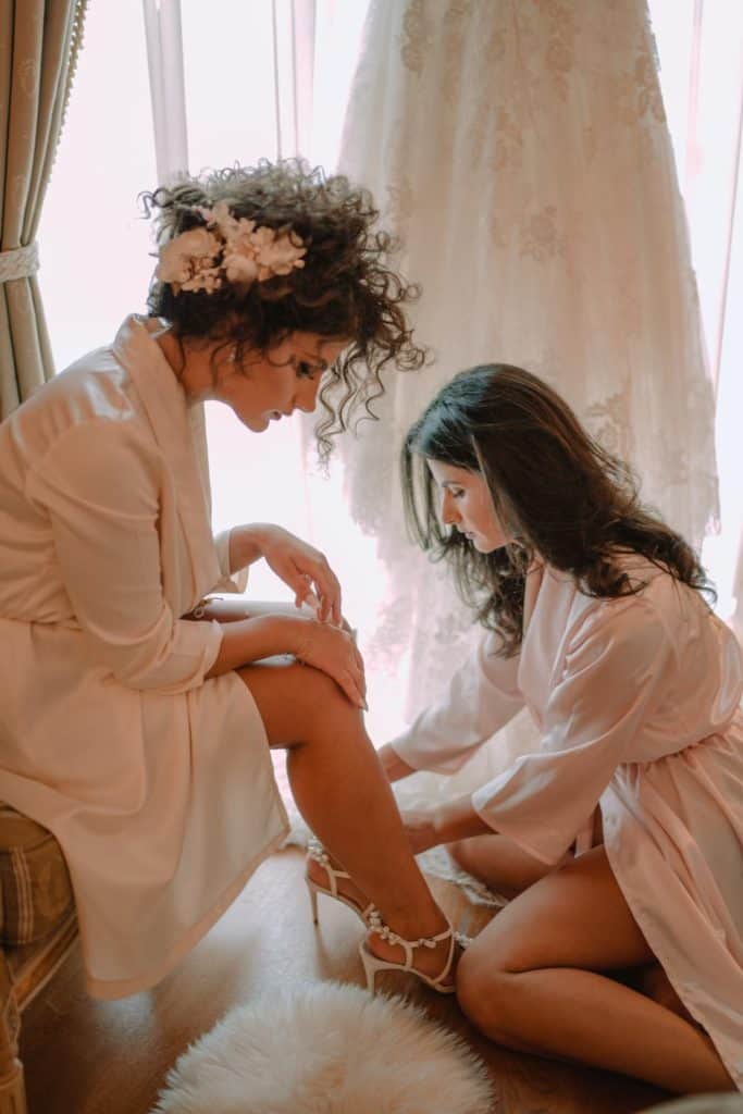 - Elegant bride getting ready with bridesmaids in high-end bridal boutique.