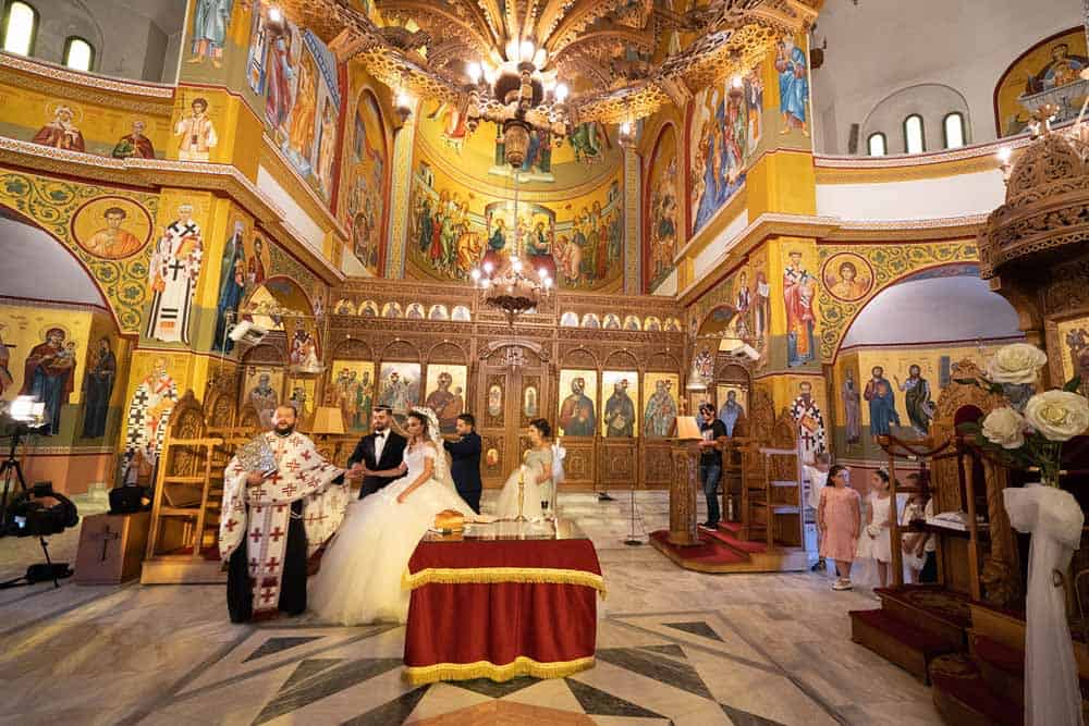 Luxurious church wedding ceremony with ornate religious icons and elegant decor.