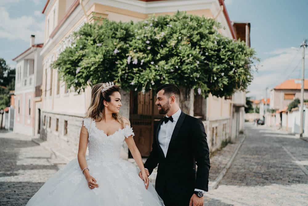 Elegant bride and groom in a luxurious wedding setting on a charming cobblestone street.