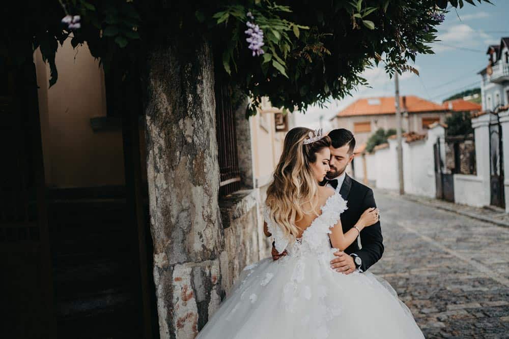 Elegant wedding couple embracing outdoors in a romantic, high-end venue setting.