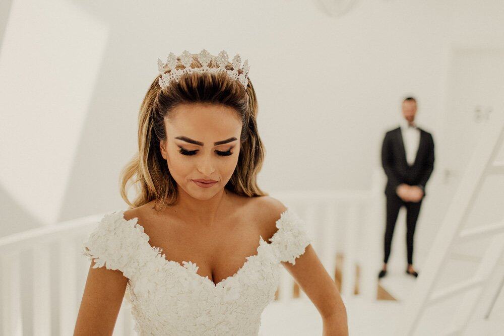 Elegant bride with a regal crown in a luxurious wedding setting, capturing a moment of anticipation before the ceremony.