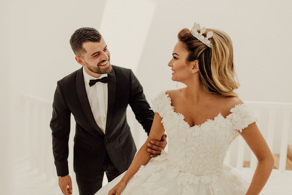 Elegant bride and groom wedding photo in luxury venue, high-end bridal attire, romantic moment, sophisticated wedding decor, classy atmosphere, Visi Studio, upscale wedding photography.