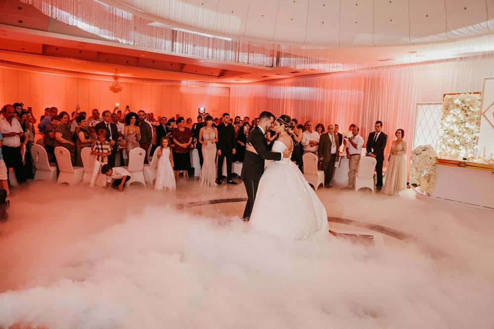Elegant wedding dance at a luxury venue with wedding guests in the background.
