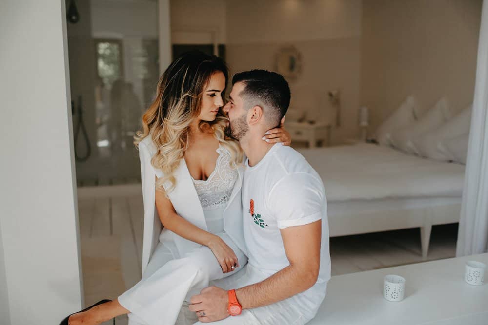 Elegant couple during a luxury wedding photoshoot in a high-end boutique hotel suite.