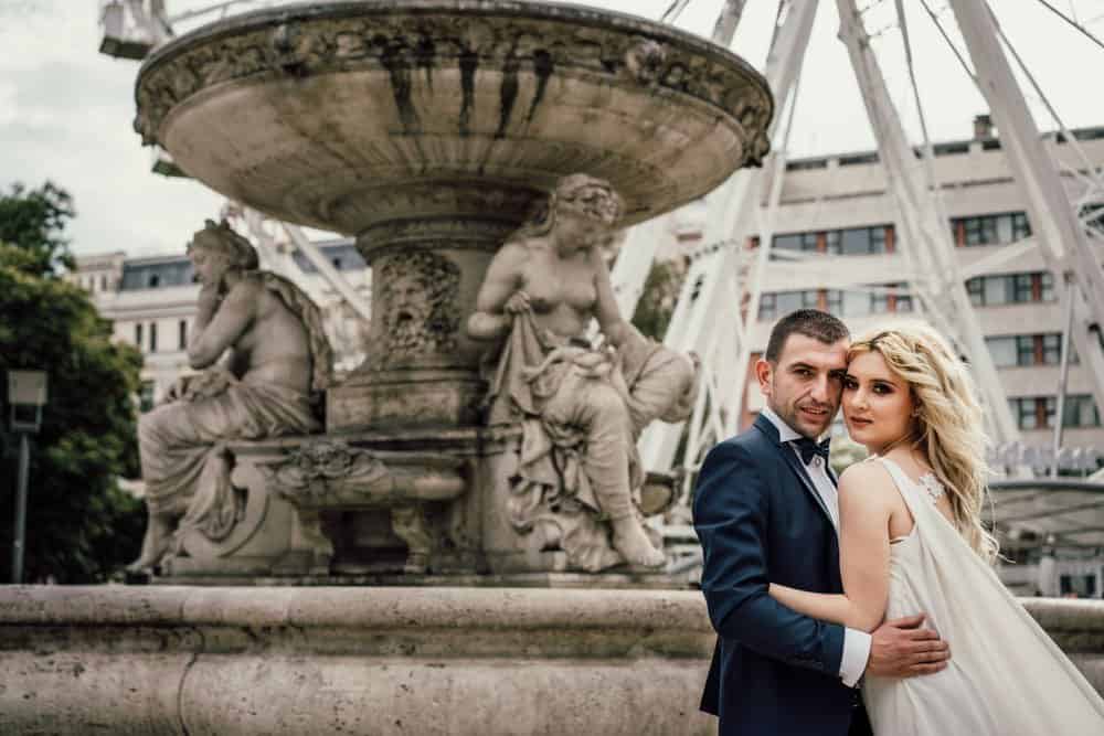 Elegant couple at iconic European fountain, perfect setting for luxury wedding photography.