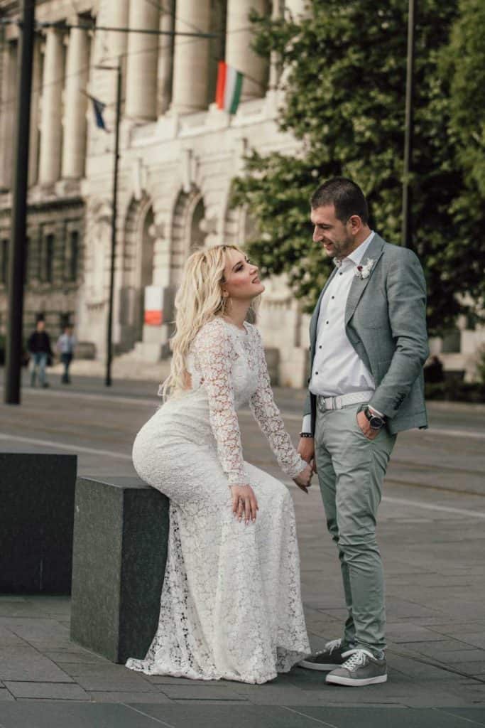 Elegant wedding couple in city street, showcasing modern wedding photography for luxury venues.