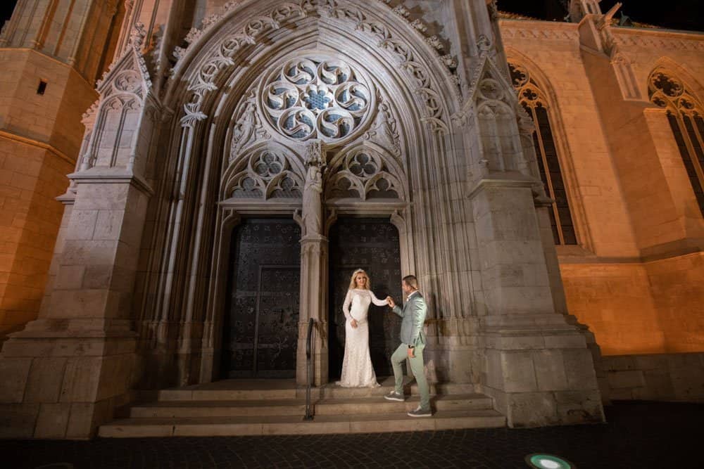 Elegant wedding couple at historic cathedral entrance, perfect luxury wedding photography.