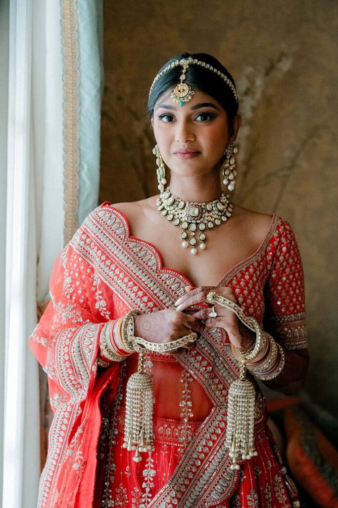 Elegant bridal portrait featuring traditional Indian jewelry and attire with luxurious detail.