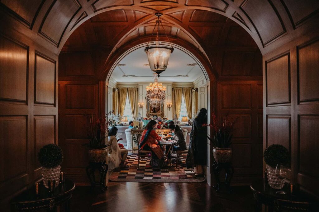 Luxury wedding reception in elegant high-end venue with ornate chandeliers and classic decor.