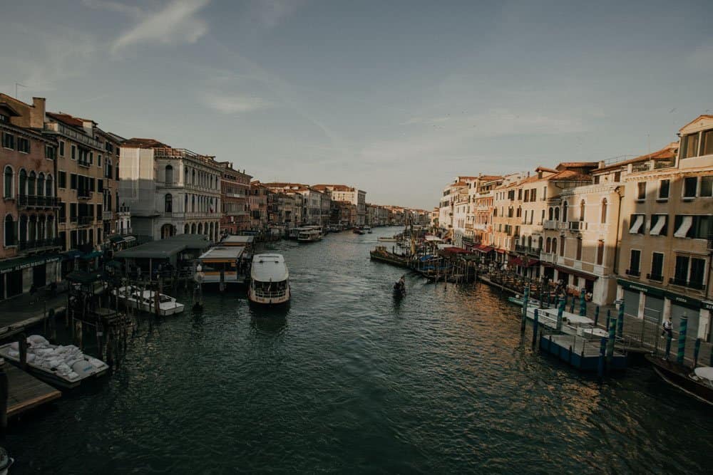 Venetian canal with luxury waterfront buildings and boats, perfect setting for high-end wedding venues.