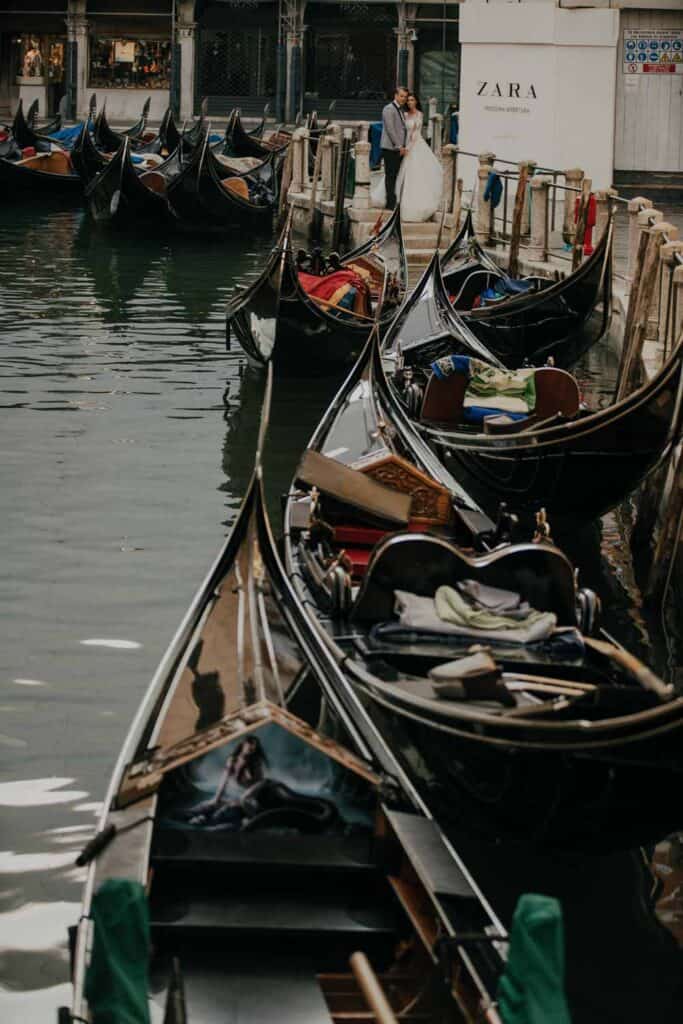 Gondolas docked at a Venice canal, showcasing luxurious romantic scenes for wedding photography or high-end event venues.