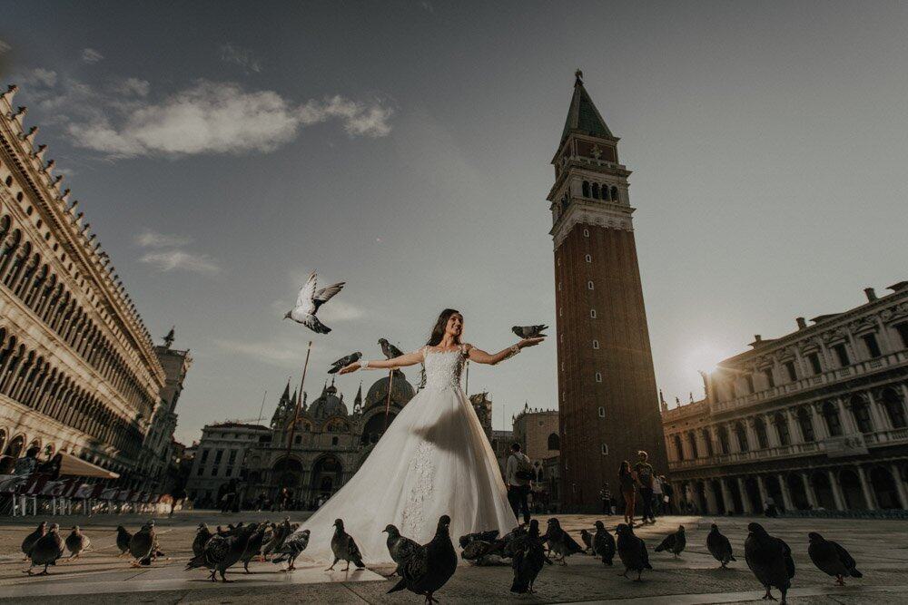 Elegant bride with pigeons in St. Mark's Square, Venice, showcasing luxury wedding photography.