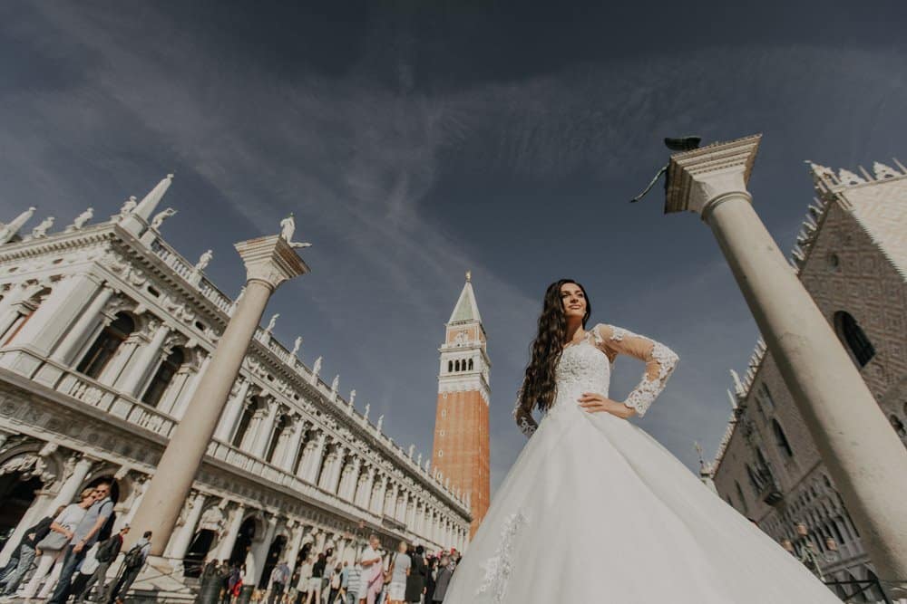Elegant bride in stunning wedding gown at historic Venice square, with iconic Campanile di San Marco in the background, perfect for luxury destination weddings.