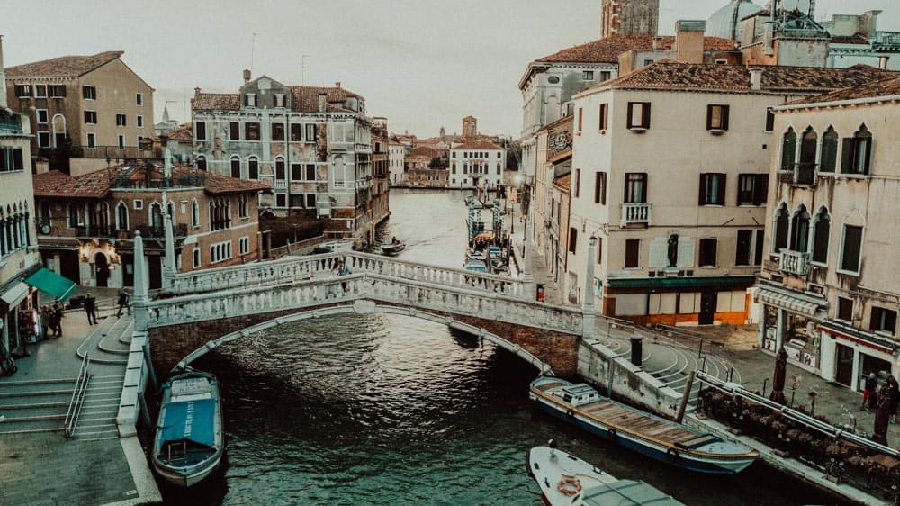 Venetian canal with historic high-end buildings and boats, perfect for luxury wedding venues.