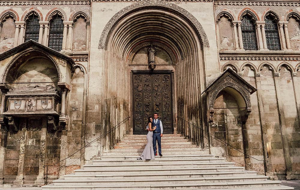 Elegant wedding couple at historic cathedral entrance, perfect for luxury wedding venues.