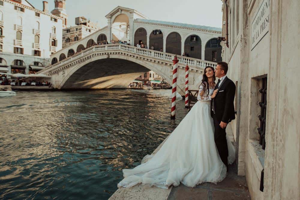 Elegant wedding couple by the Grand Canal in Venice, Italy, highlighting luxury wedding destination and high-end venue setting.