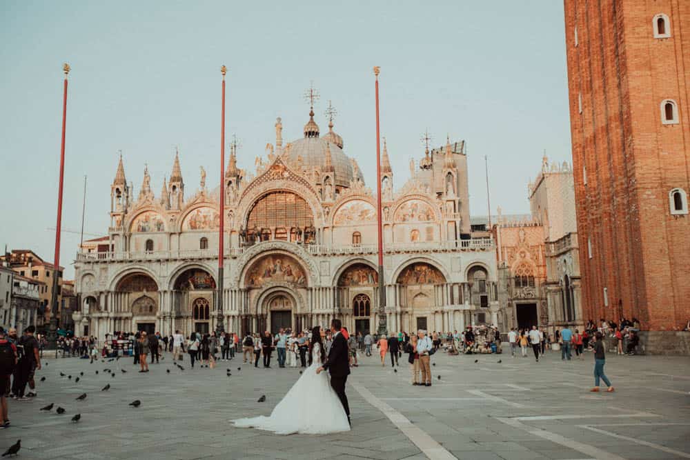 Venetian cathedral and a romantic wedding couple in Piazza San Marco, Venice, Italy.