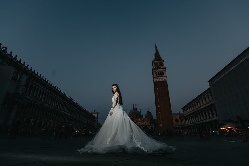 Elegant bride in a luxurious wedding gown at a high-end Venice square, showcasing romantic European architecture.