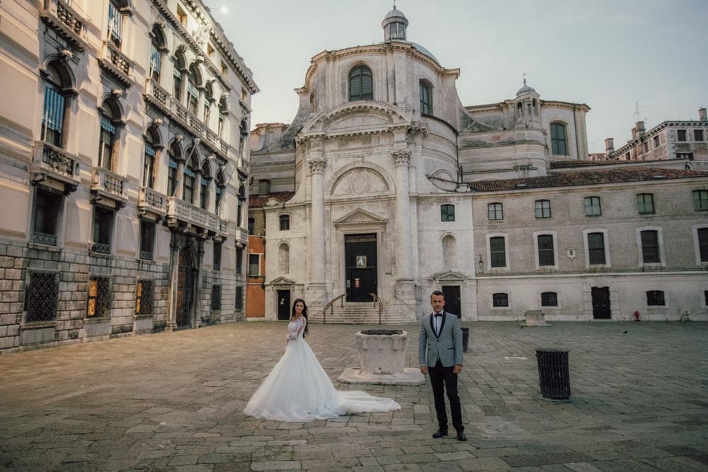 Elegant wedding couple in front of historic church, perfect for luxury wedding venues and high-end event photography, capturing romantic and sophisticated moments.