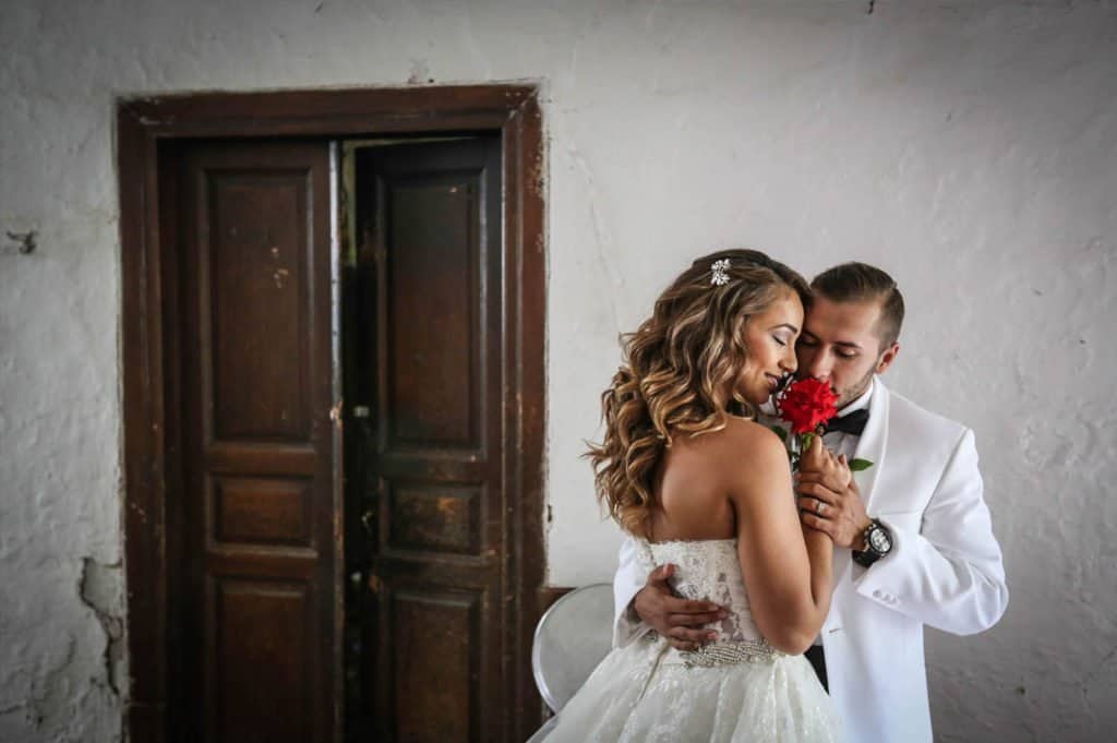Elegant wedding couple sharing a romantic moment indoors, capturing the intimacy and luxury of high-end wedding venues.