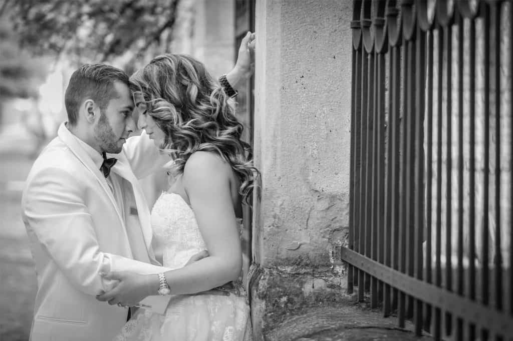 Elegant couple sharing a romantic moment outdoors in black and white, perfect for luxury wedding photography.