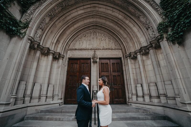 Elegant wedding couple in front of historic church entrance, capturing a luxurious wedding moment in a high-end venue, perfect for upscale wedding planning and photography.