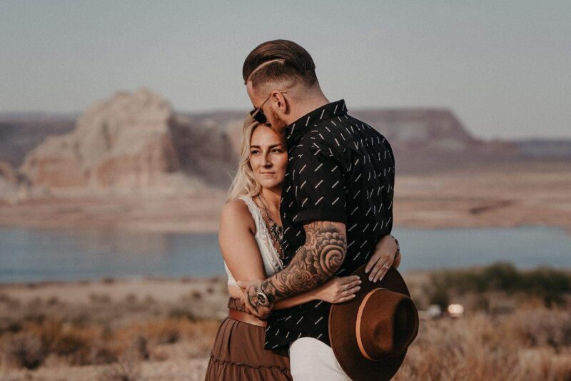 Romantic couple embracing outdoors with Grand Canyon in background, capturing a luxurious wedding or engagement scene.