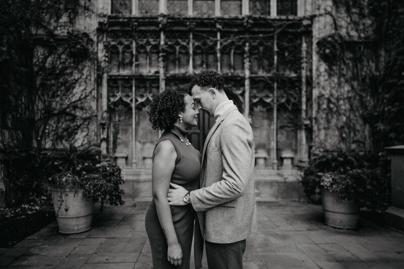 Elegant couple sharing an intimate moment outdoors at a luxury wedding venue in black and white photography.