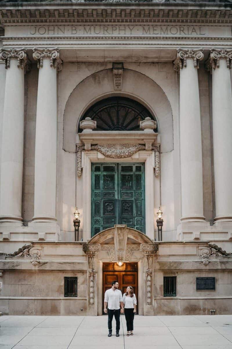 Elegant wedding couple standing outside historic courthouse in luxury wedding photos.