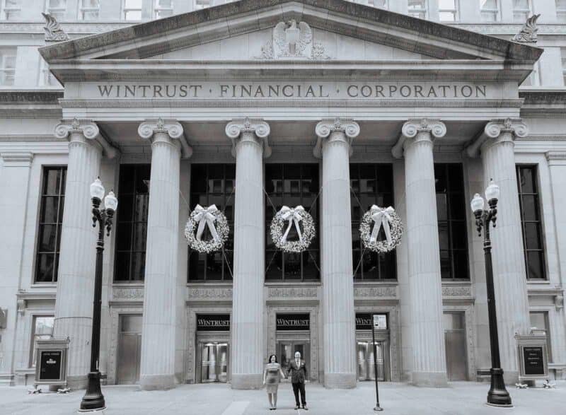 Elegant historic financial building decorated for a luxury wedding reception with white wreaths and ribbons.