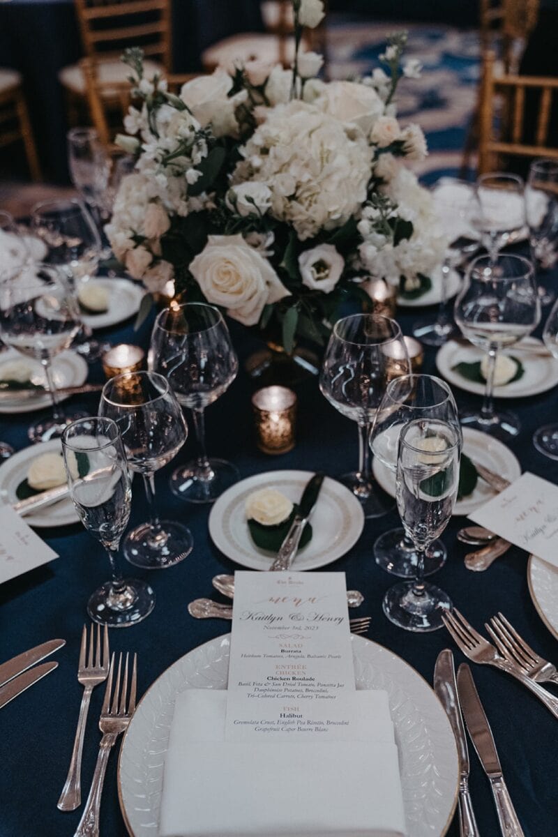 Luxurious wedding table setting with elegant floral centerpiece and fine china.