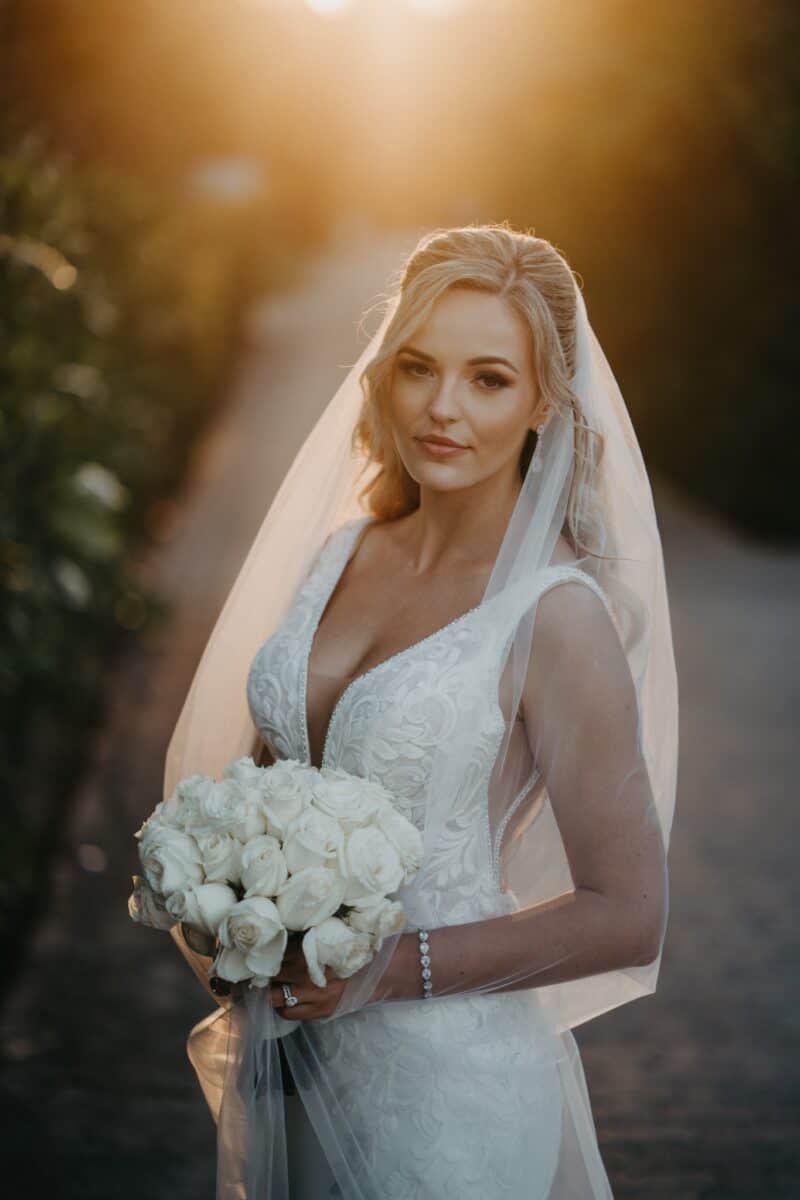 Luxury wedding bride portrait at high-end outdoor venue with sunset lighting.