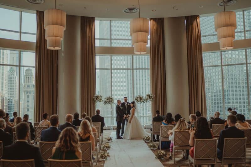 Elegant wedding ceremony in a luxury urban hotel with panoramic city views and sophisticated decor.