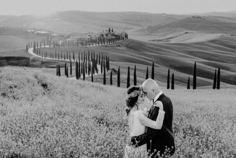 Lavender field wedding scene with a couple embracing, in black and white, showcasing romantic high-end wedding photography.