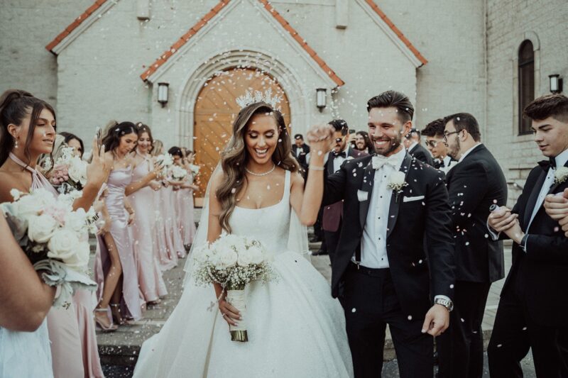 Elegant wedding celebration outside a high-end venue with joyful bride and groom.