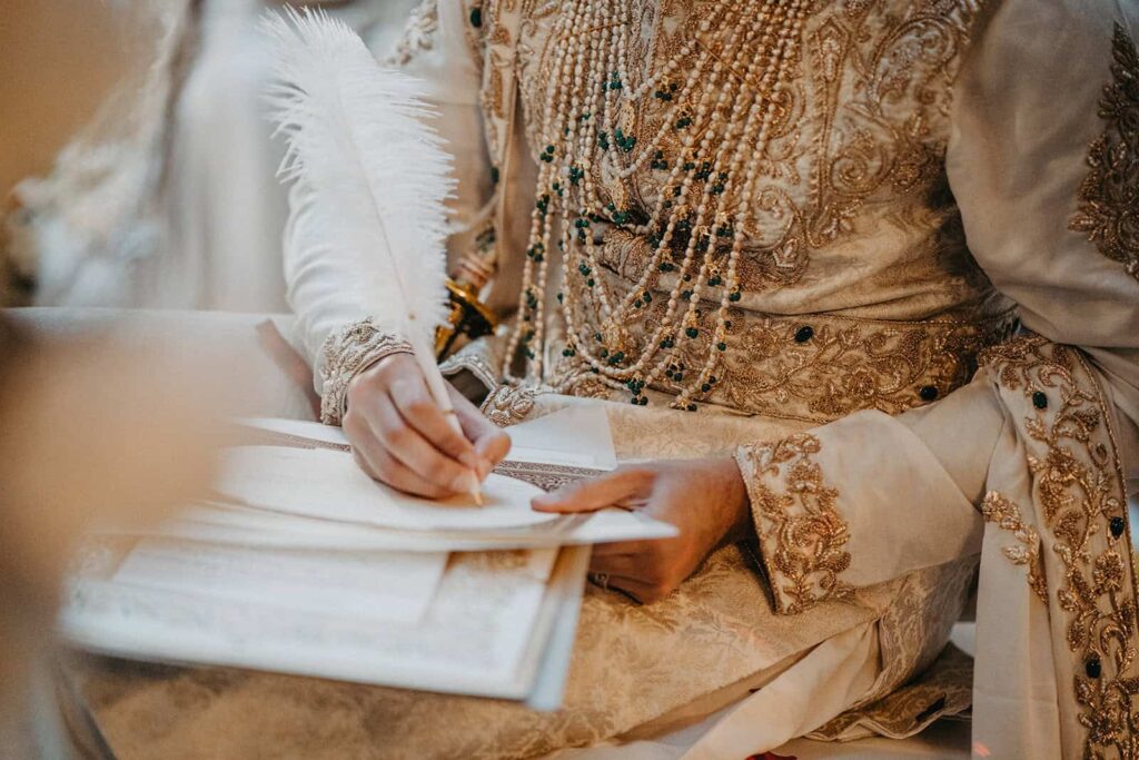 Elegant traditional embroidered wedding attire with intricate gold beading and jewelry.