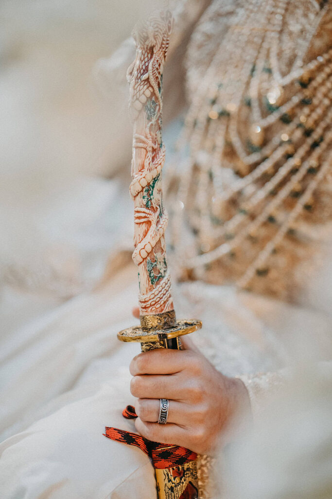 Exquisite ornate sword with intricate dragon pattern, used in a luxury wedding ceremony.