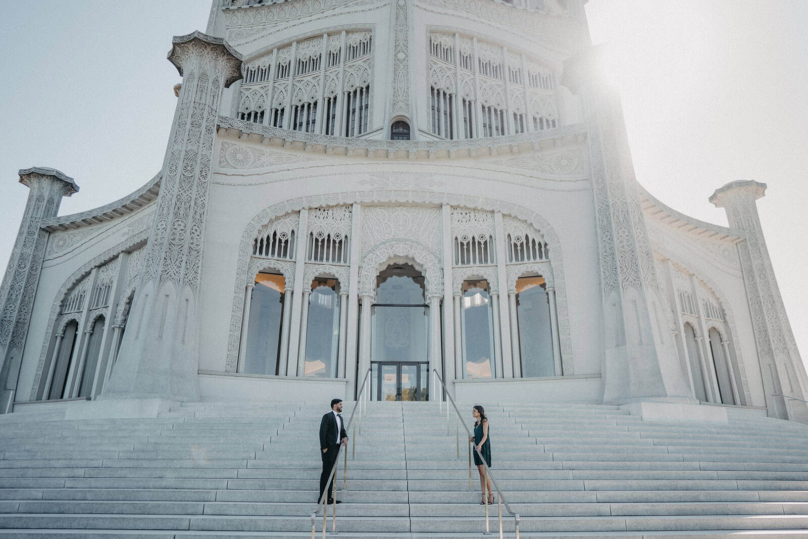 Elegant wedding at a luxurious white marble high-end venue with intricate architectural details and grand staircase.