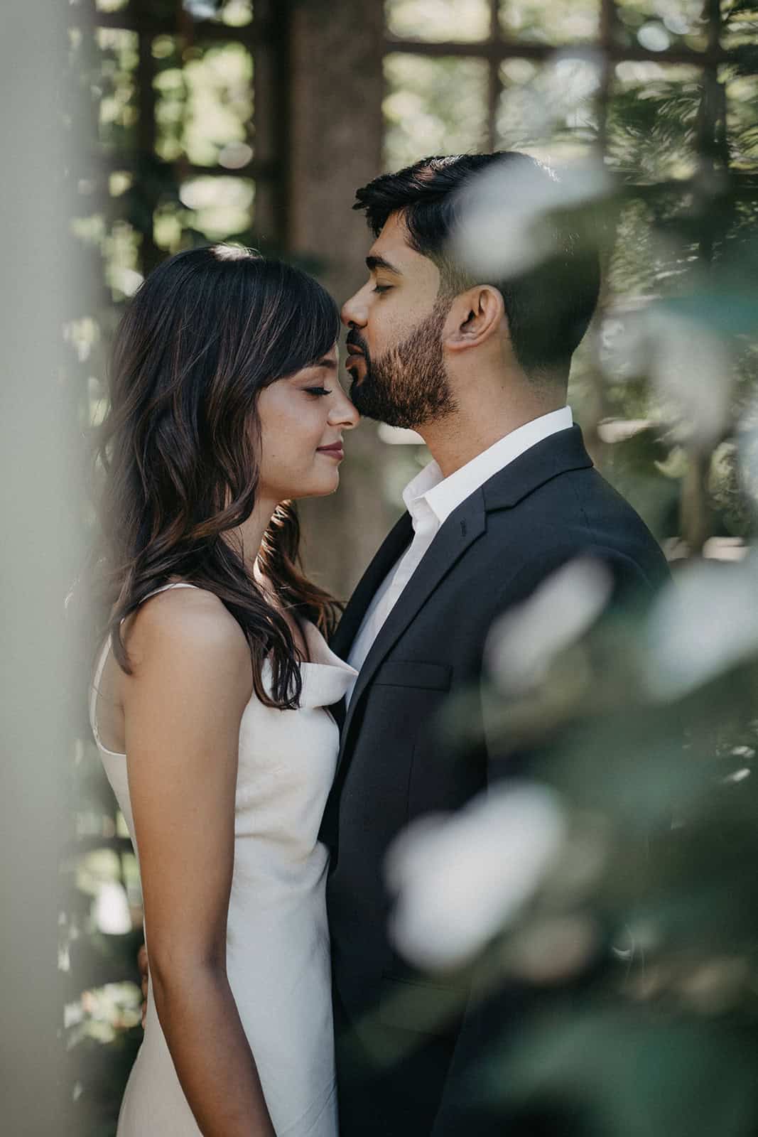 Elegant couple sharing an intimate moment outdoors for a luxury wedding photoshoot.