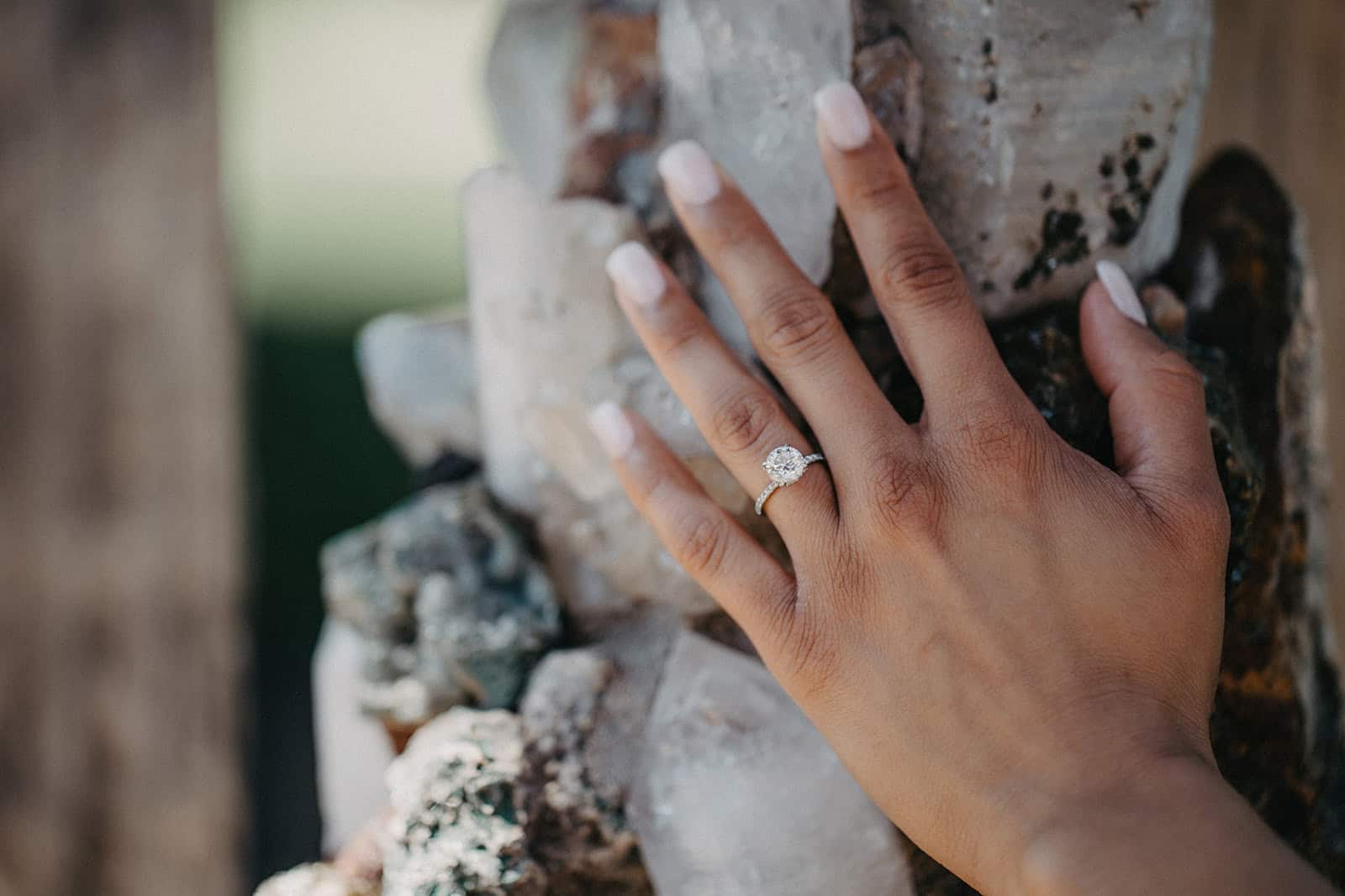 Elegant engagement ring with a large round-cut diamond on a woman's hand, showcasing luxury jewelry for high-end wedding planning.