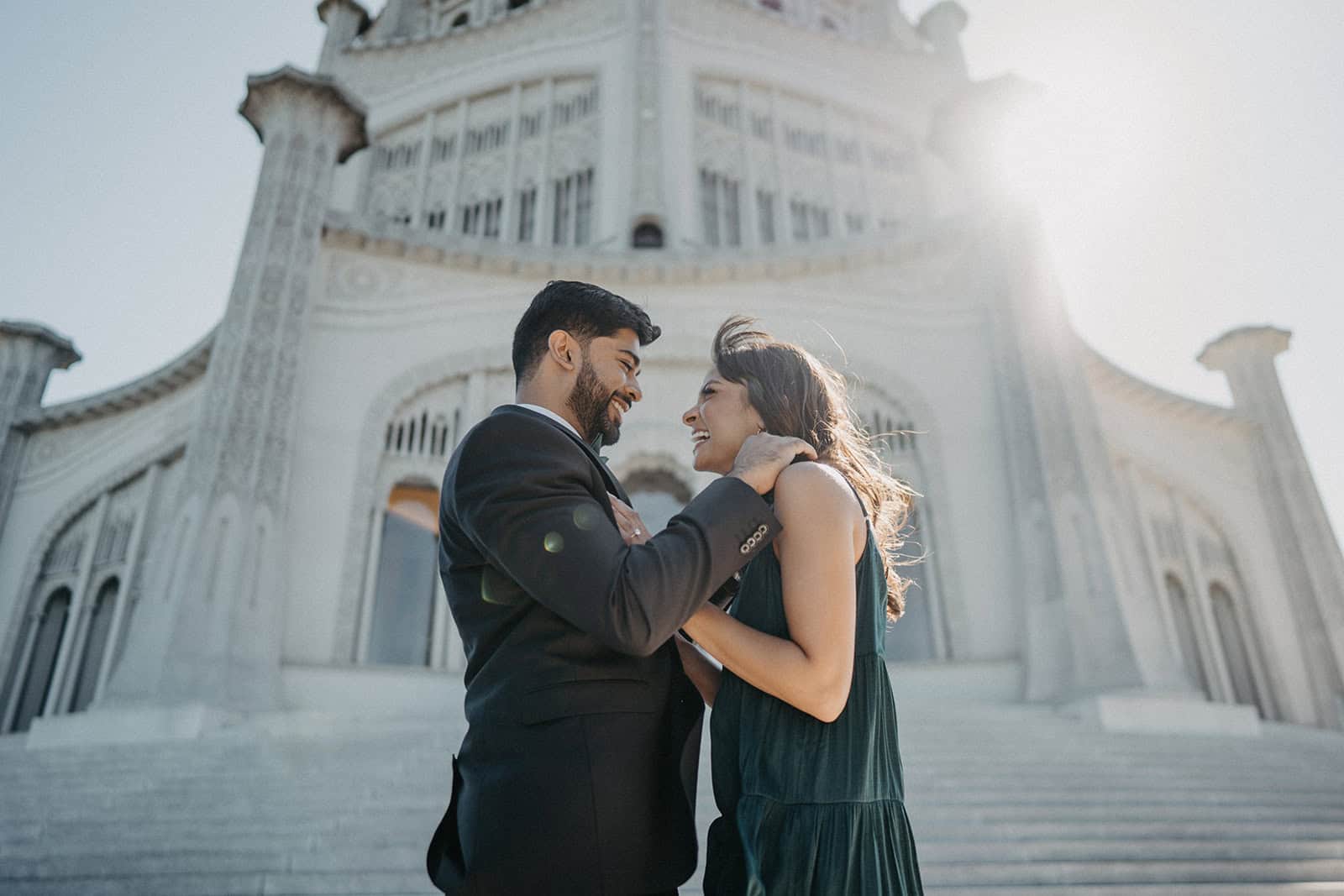 Elegant couple celebrating romance at a luxury wedding venue in front of a grand historic building.
