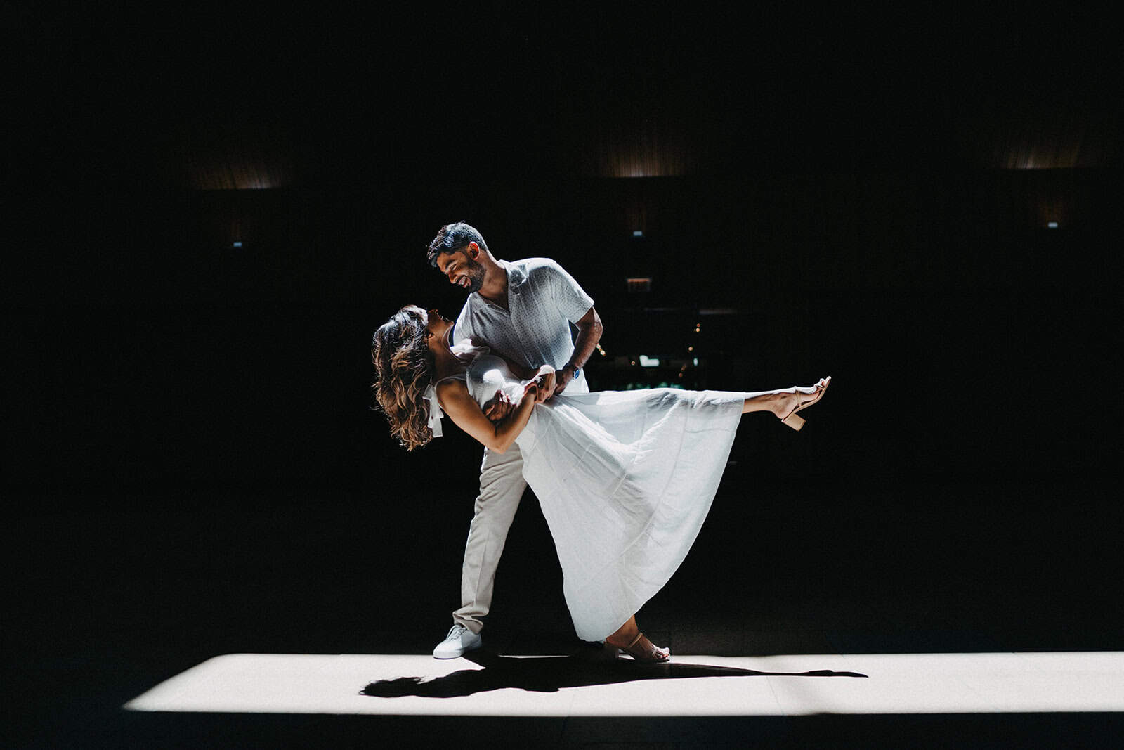 Elegant couple dancing at a luxury wedding reception in a high-end venue, spotlight highlighting their joyful moments.