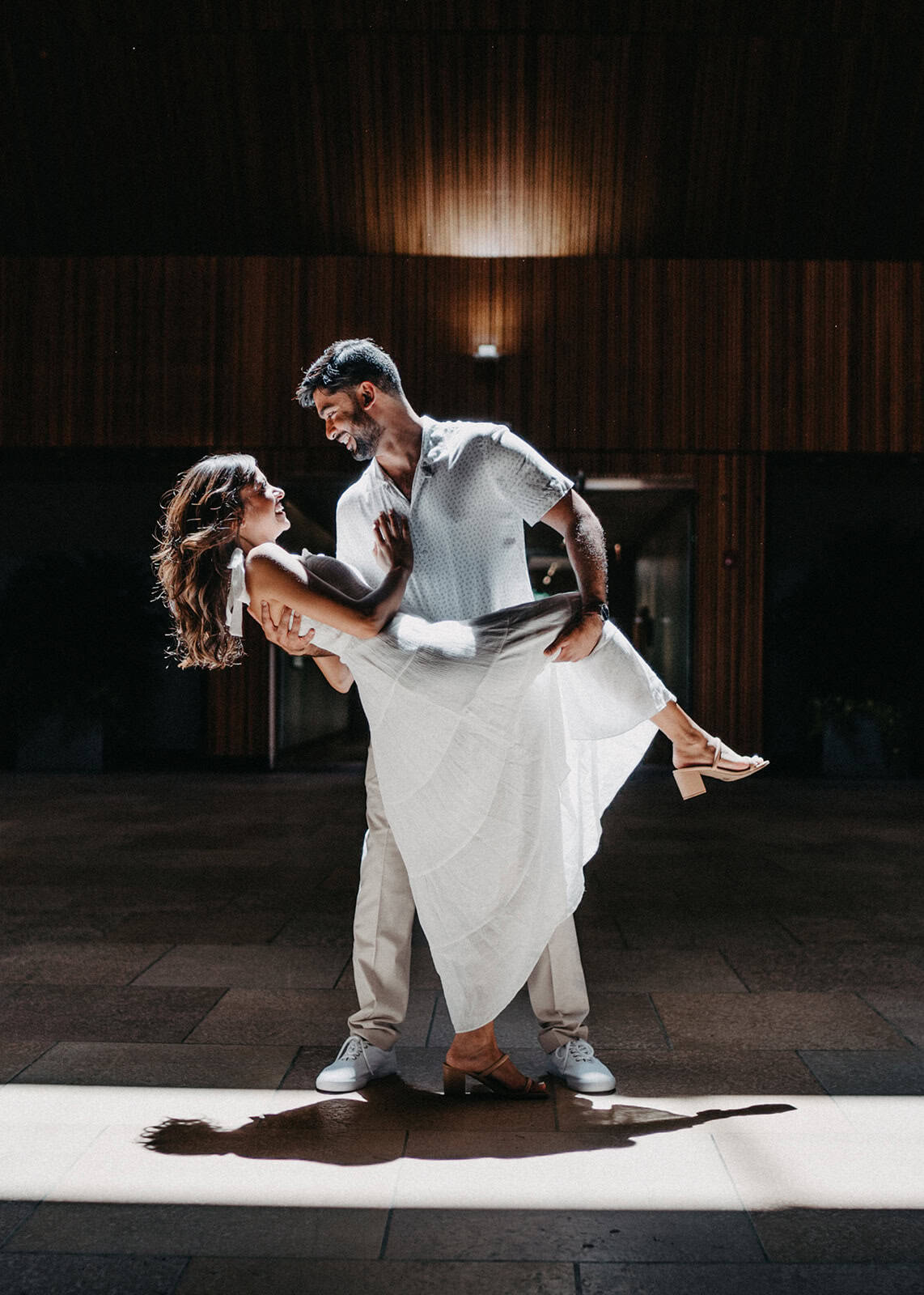Elegant couple dancing during wedding celebration in a modern venue, capturing romance and joy.