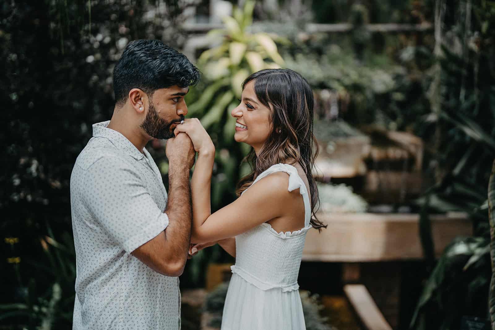Elegant couple sharing a romantic moment in a lush, botanical garden setting for a luxury wedding photoshoot.