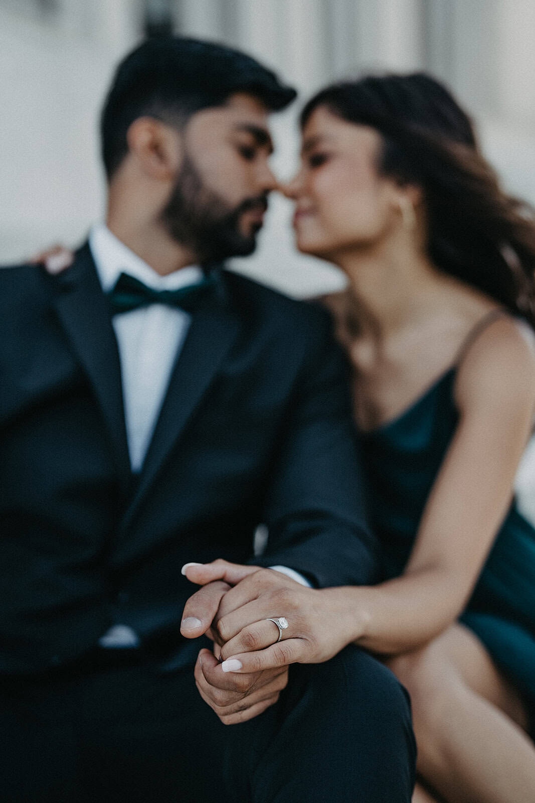 Luxury wedding couple holding hands with engagement ring, romantic intimate moment in elegant high-end venue.