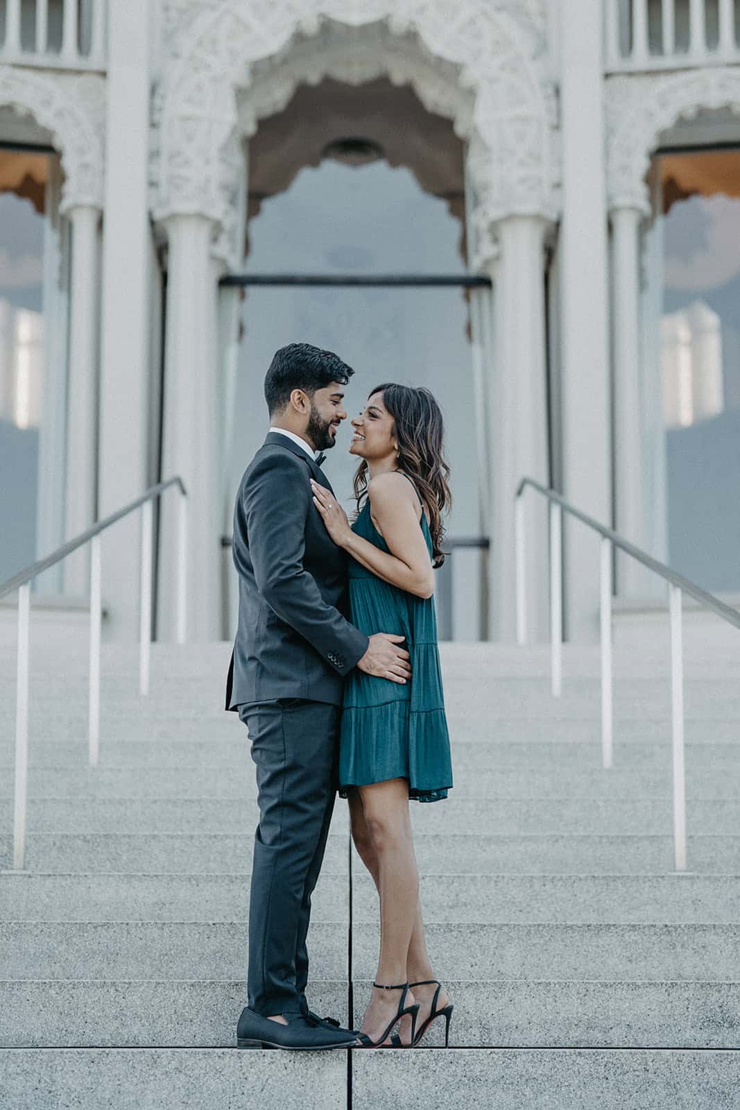 Elegant couple sharing a moment outdoors at a luxury wedding venue with intricate architecture.