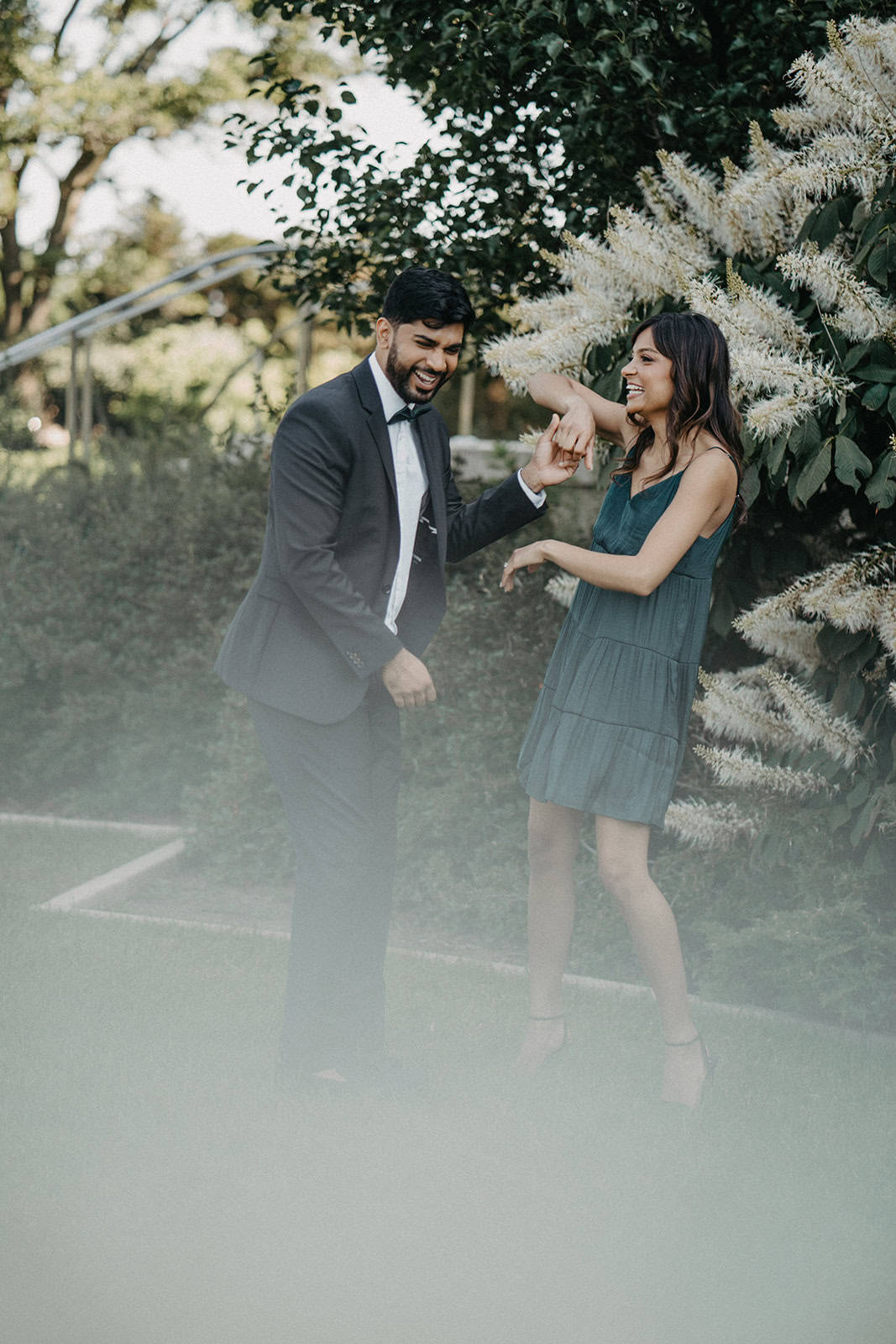 Elegant romantic couple enjoying outdoor wedding celebration with lush garden backdrop.