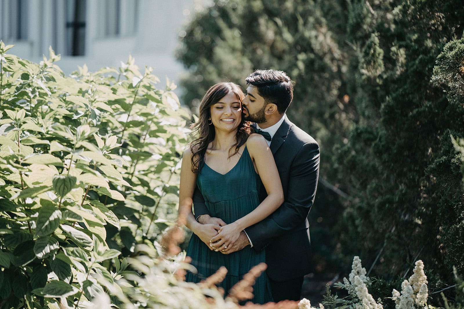 Elegant outdoor wedding photo featuring a happy couple in a lush garden setting, perfect for luxury wedding venues.